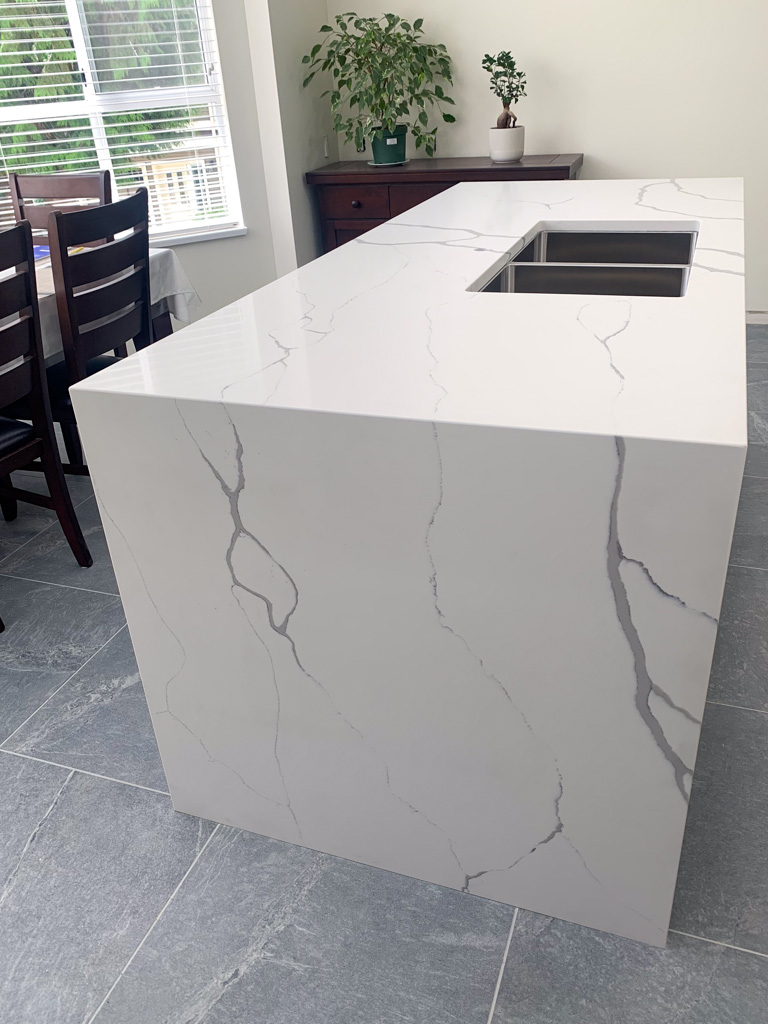 Kitchen with large format porcelain tiles and waterfall countertop