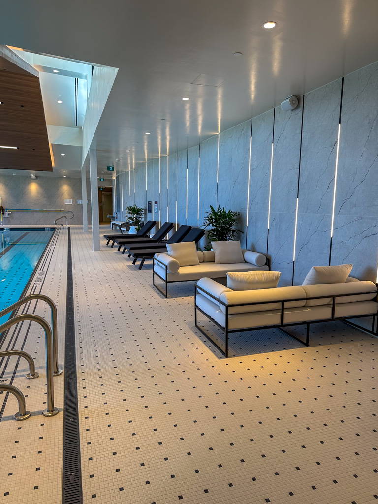 Commercial pool space with large format tiles on the wall and mosaic tile on the floor