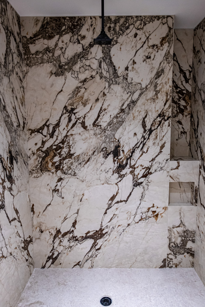 Modern shower with large-format marble walls and ceiling rain shower
